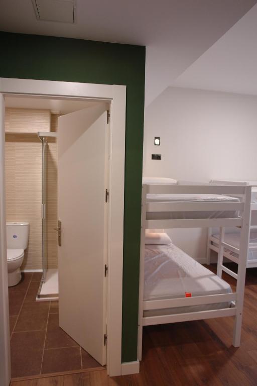 Pokój z 2 łóżkami piętrowymi i toaletą w obiekcie Hostel Trovadores w mieście Burgos