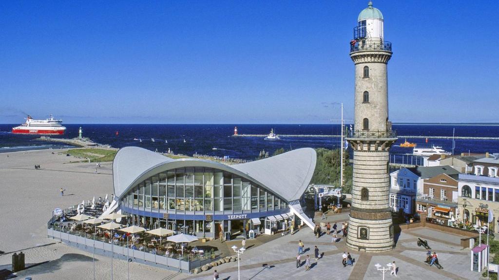 a lighthouse next to a building and a building with a tower at Ferienunterkunft Ostsee Rostock in Mönchhagen