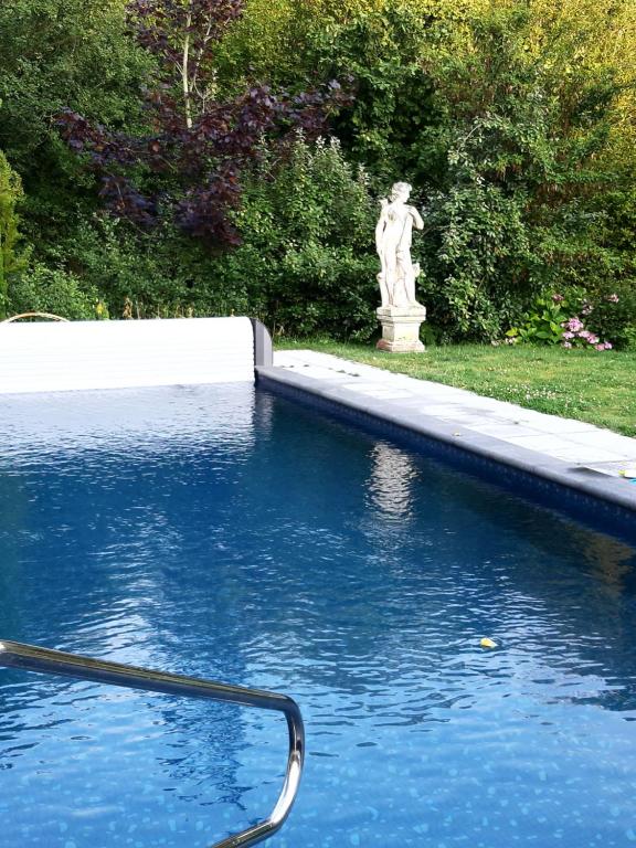 una piscina con una estatua en un patio en De Galerie - Landgoed Rijckholt, en Geersdijk