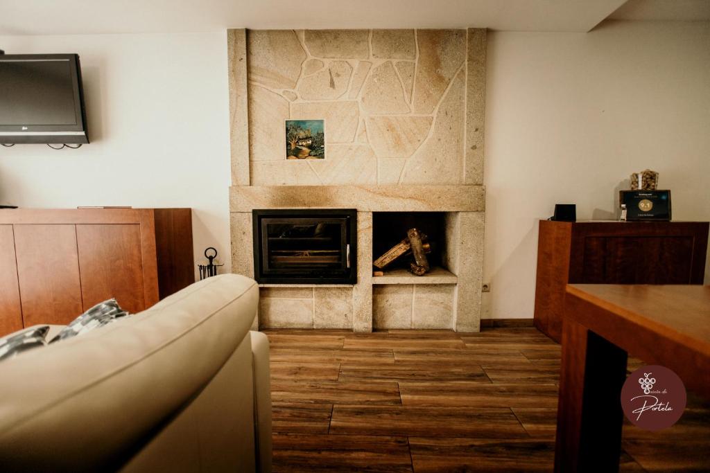 ein Wohnzimmer mit Kamin und Couch in der Unterkunft Casa da Adega - Quinta da Portela in Terras de Bouro