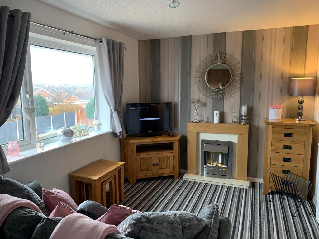 a living room with a couch and a tv and a fireplace at Sunny rhyl apartment in Rhyl