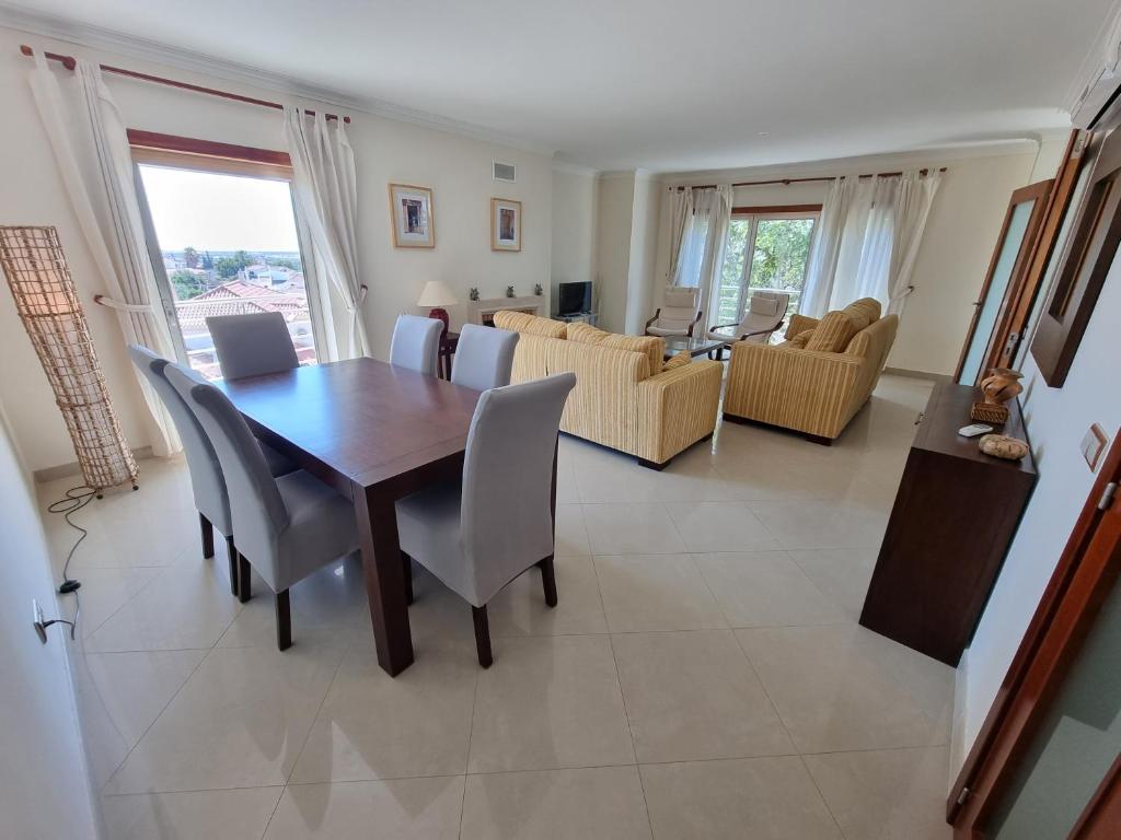 a dining room and living room with a table and chairs at Apartamento em Tavira by Homekeys in Tavira