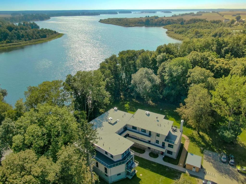 eine Luftansicht eines Hauses neben einem Fluss in der Unterkunft Ferienwohnungen am Wasser - Krakow am See in Krakow am See