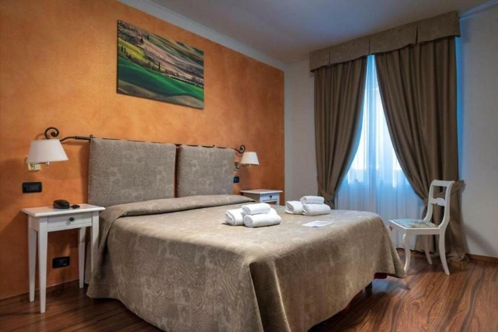 Postel nebo postele na pokoji v ubytování Hotel Arcobaleno Siena