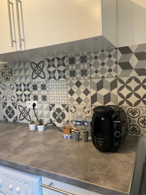 - un comptoir de cuisine avec une cafetière et du carrelage dans l'établissement Studio cosy au cœur du centre ville idéal pour visiter Marseille, à Marseille