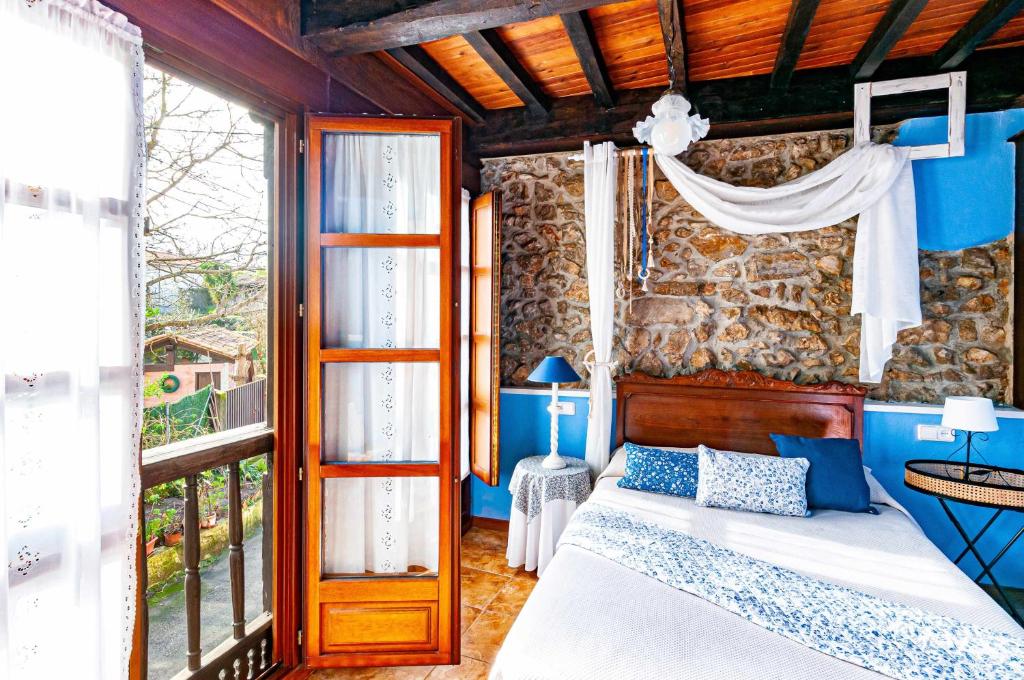 a bedroom with a bed and a stone wall at Casa Conce Zona de playa y montaña in Llanes