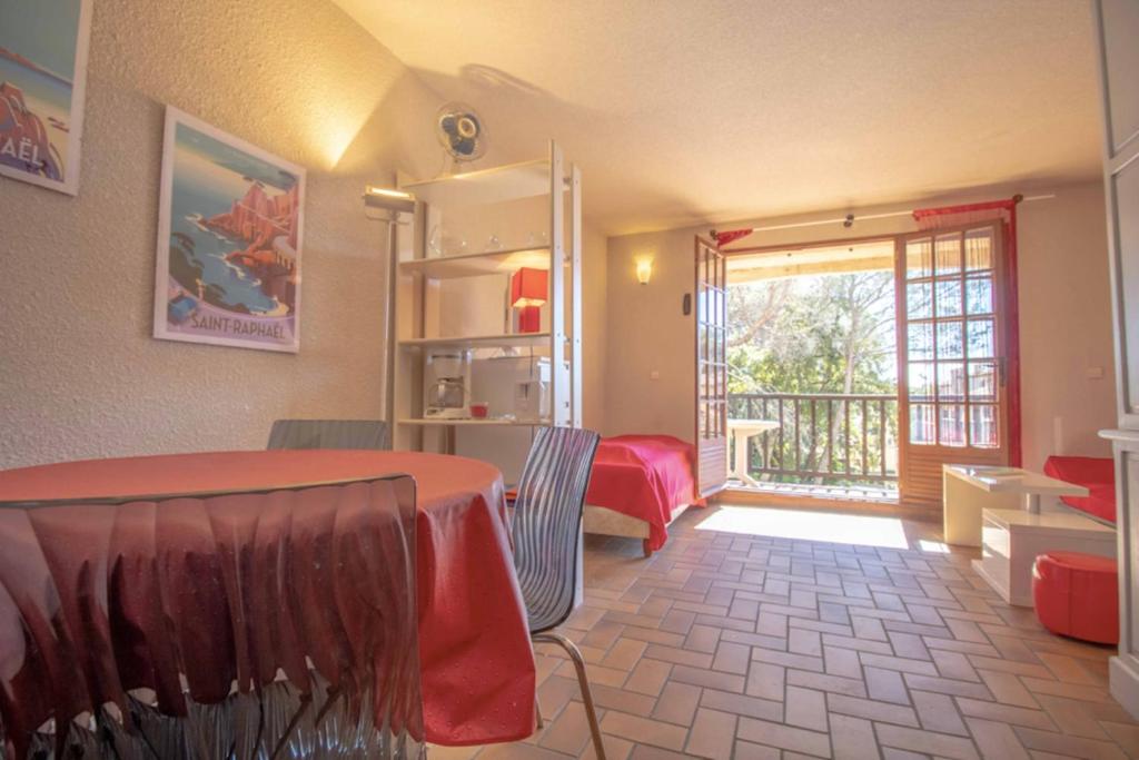 a room with a table and chairs and a balcony at Nice 35m At 450m From The Beach in Saint-Raphaël