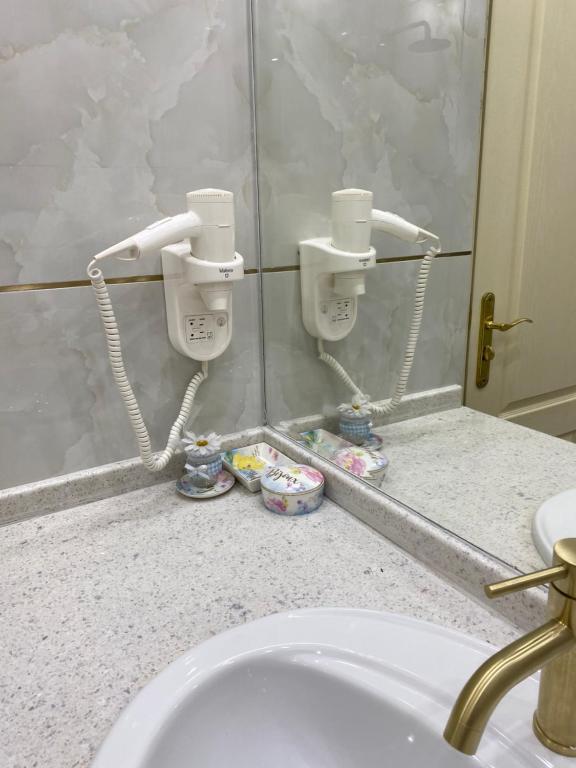 a bathroom with a sink and two soap dispensers at SPA Apartament Sirius house in Saints Constantine and Helena