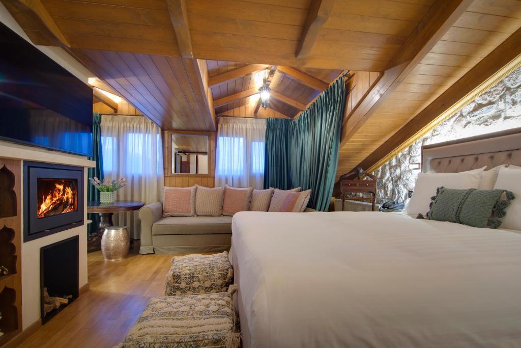 a bedroom with a large bed and a fireplace at ARCHONTARIKI Historic Boutique Hotel in Ioannina