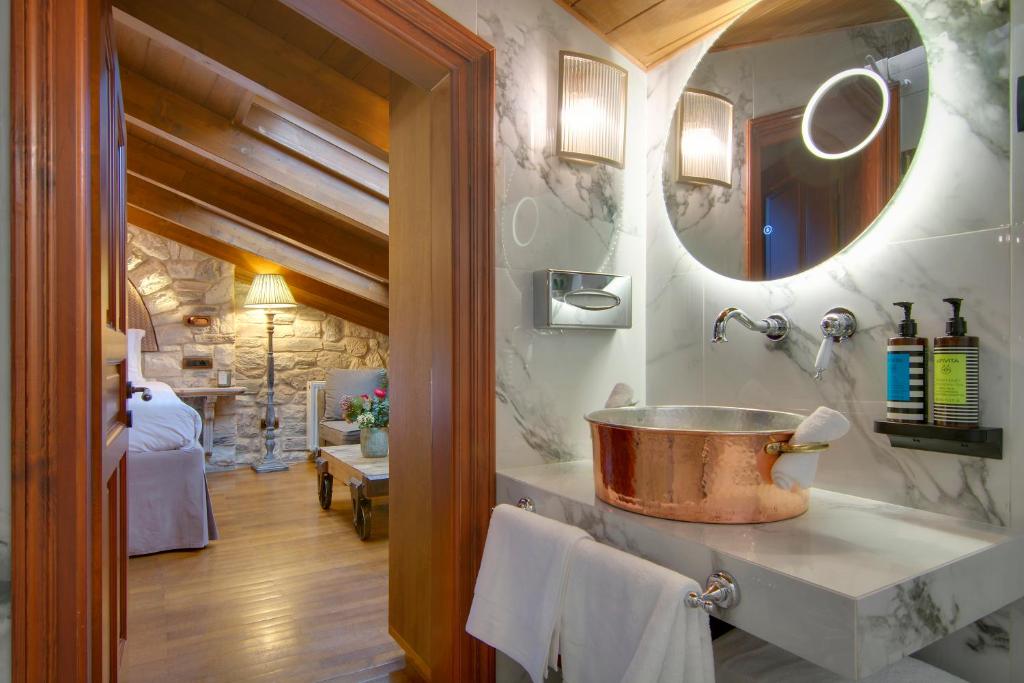 a bathroom with a copper sink and a mirror at ARCHONTARIKI Historic Boutique Hotel in Ioannina