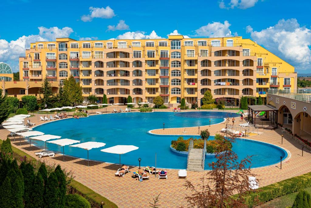 um hotel com uma grande piscina em frente a um edifício em Menada Grand Resort Apartments em Aheloy