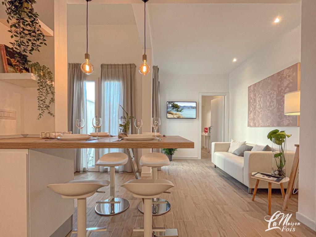 a kitchen and living room with a bar with stools at La Maison Fois - Appartamento Quartucciu in Quartucciu