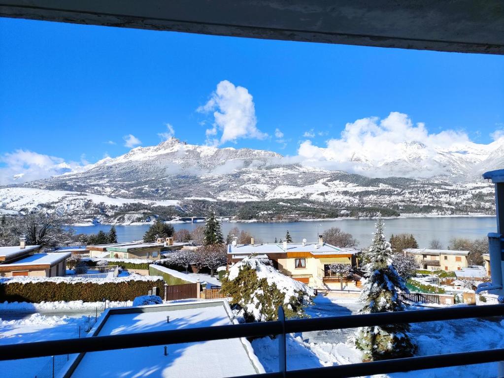 Blick auf einen verschneiten Berg aus dem Fenster in der Unterkunft Studio vue sur lac et montagne in Savines