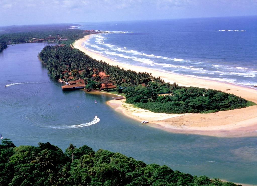 an island in the ocean next to a beach at Club Bentota in Bentota