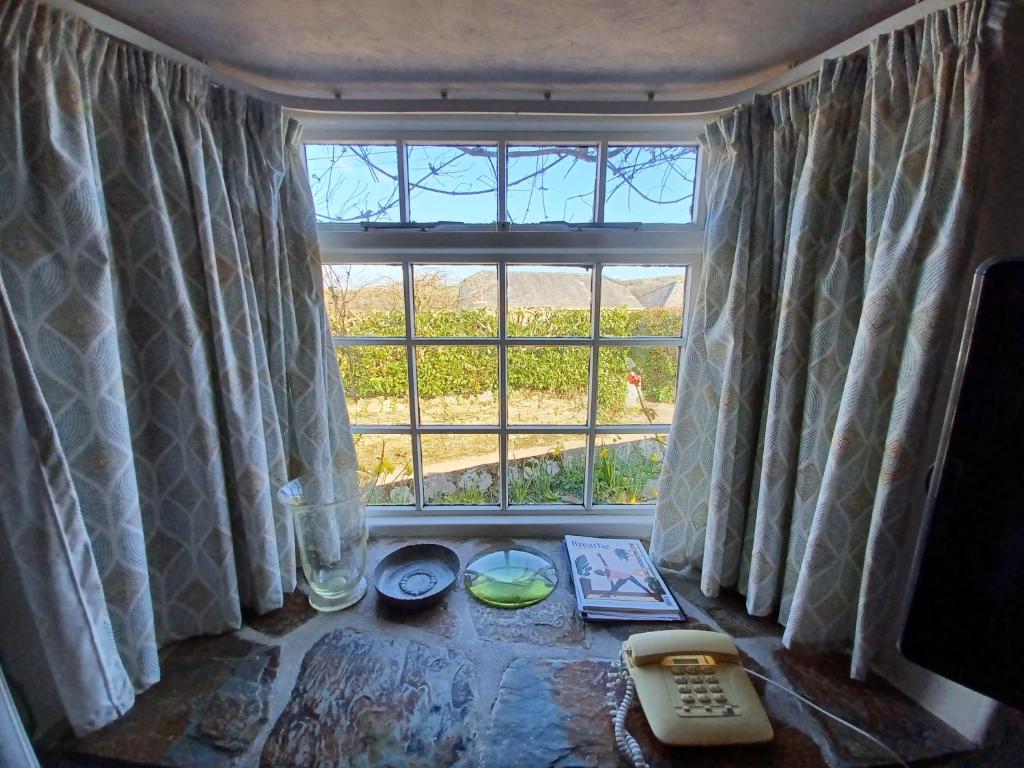 a room with a large window and a remote control at Truly Paradise Cottage in Golant