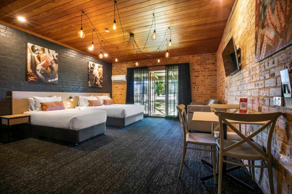 une chambre d'hôtel avec 2 lits et un bar dans l'établissement Nightcap at Macquarie Inn, à Dubbo