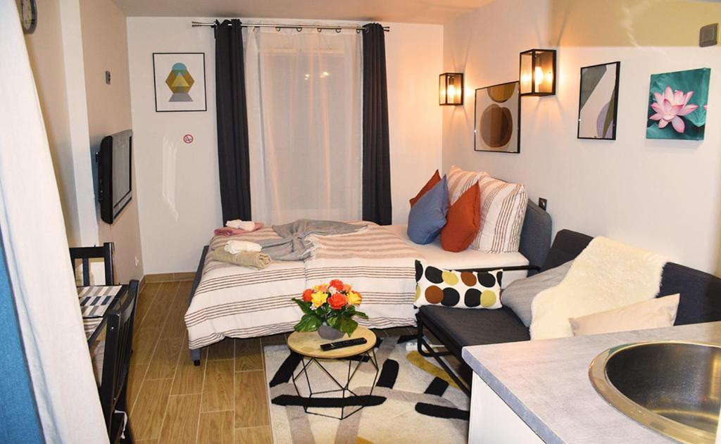 - un petit salon avec un lit et un canapé dans l'établissement Apartment at Paris-Defense Arena Free parking by Servallgroup, à Courbevoie