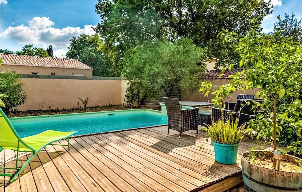 a backyard with a swimming pool and a wooden deck at Stunning Home In Saint-quentin-la-poter With Outdoor Swimming Pool in Saint-Quentin-la-Poterie