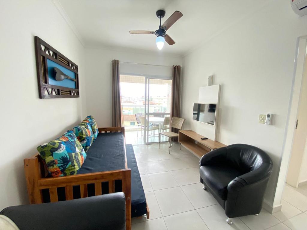 ein Wohnzimmer mit einem Sofa und einem Tisch in der Unterkunft Apartamento com excelente localização e conforto! in Ubatuba