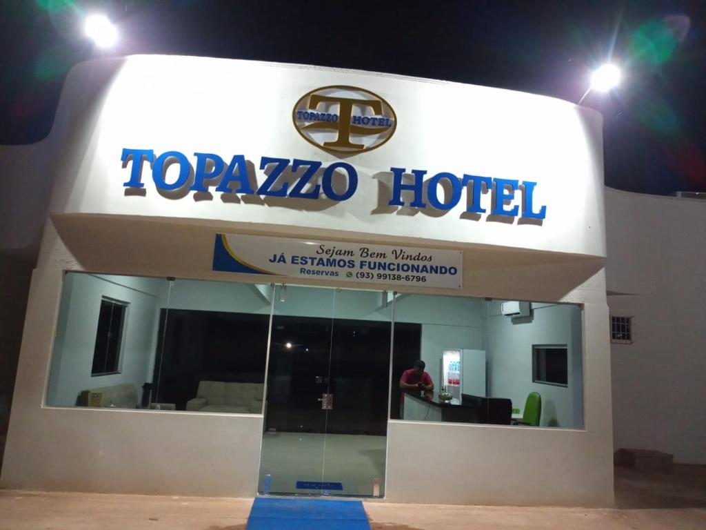a tozazo hotel sign in front of a building at Topazzo Hotel in Uruara