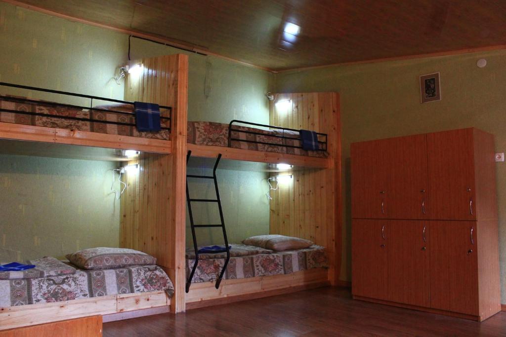 a room with three bunk beds and a ladder at Homestay in Stepantsminda