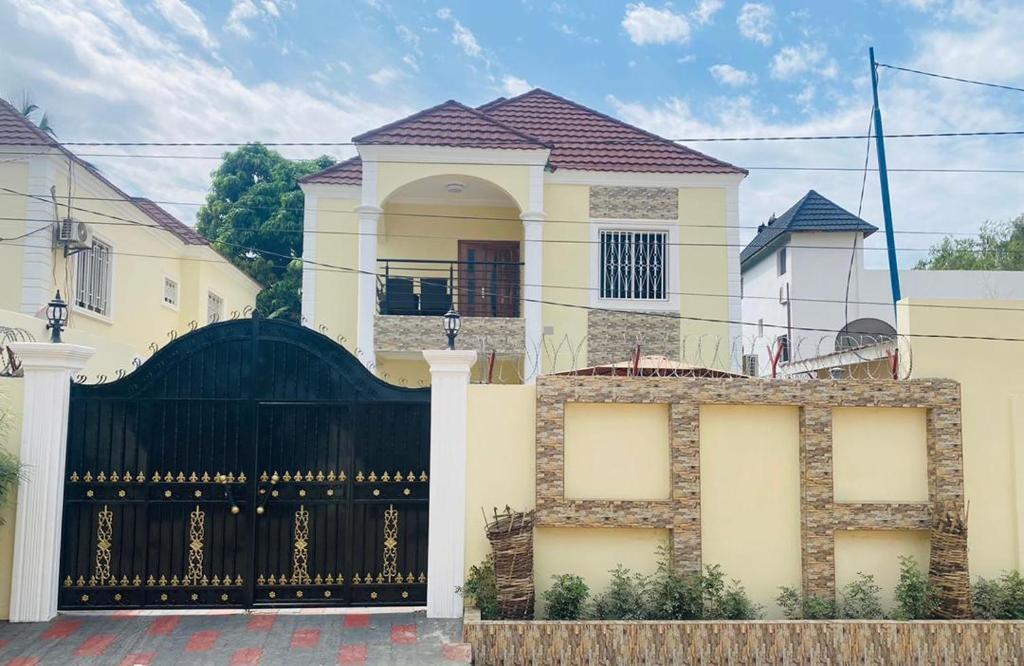 una gran casa blanca con una puerta negra en Janha's Senegambia Villa Holiday Rental With Free Wifi, en Amdalai