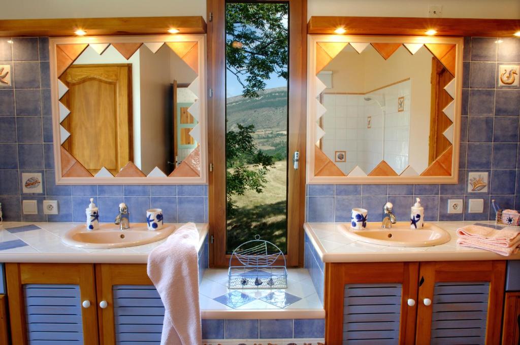 La Roche-des-ArnaudsにあるLe Clos de Lumièreの洗面台が2つと大きな窓があるバスルーム