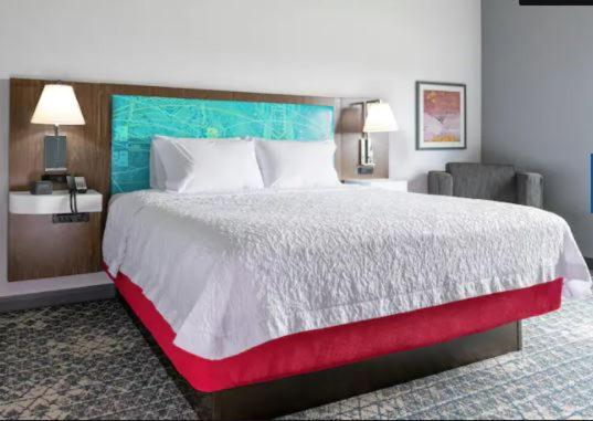 - une chambre avec un grand lit et une couverture rouge dans l'établissement Hampton Inn & Suites Chico, Ca, à Chico