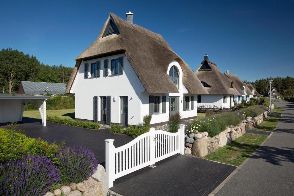 a group of homes with a thatched roof at Ferienhaus Schilfrohrsaenger 6 in Fuhlendorf