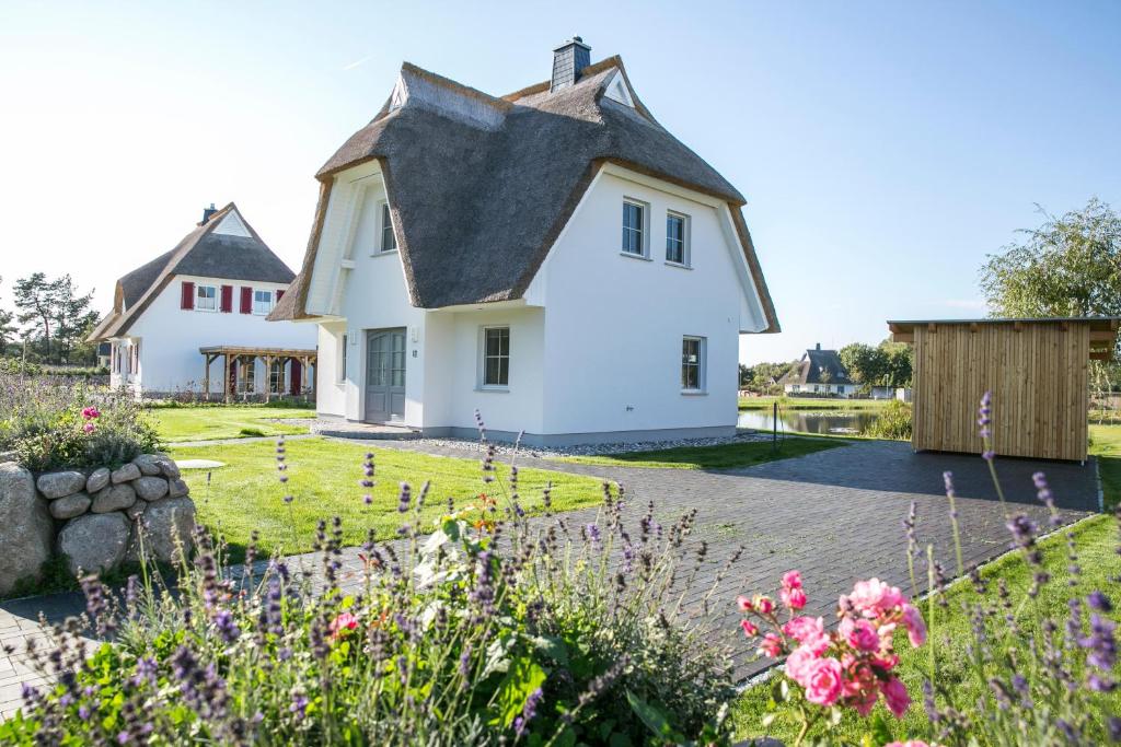 een wit huis met een zwart dak bij Ferienhaus Seeschwalbe 60 in Fuhlendorf