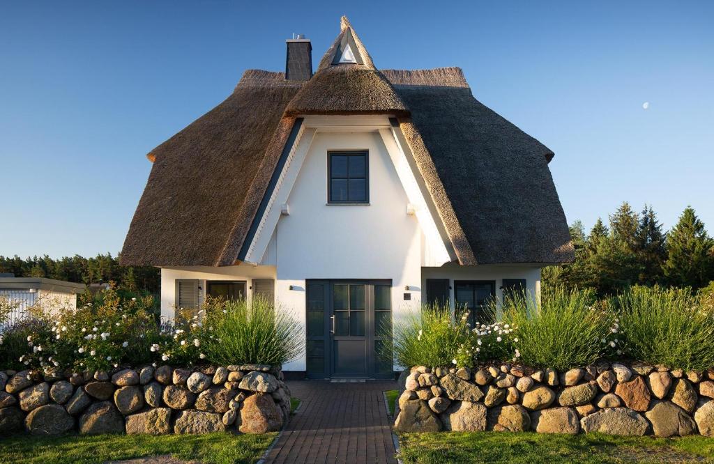 a cottage with a thatched roof and a walkway at Ferienhaus Seeschwalbe 44 in Fuhlendorf