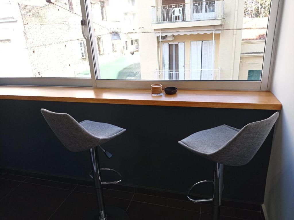 two chairs sitting at a counter in front of a window at NY Central 1 in Patra