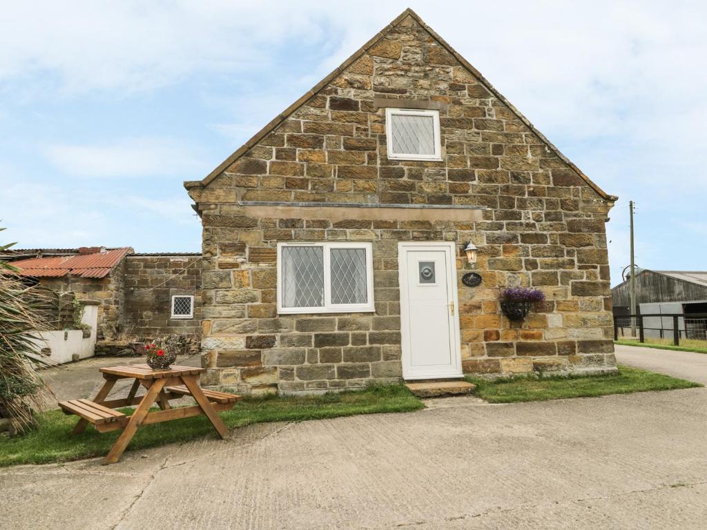 a stone house with a picnic table in front of it at Foxhunter Cottage in Whitby