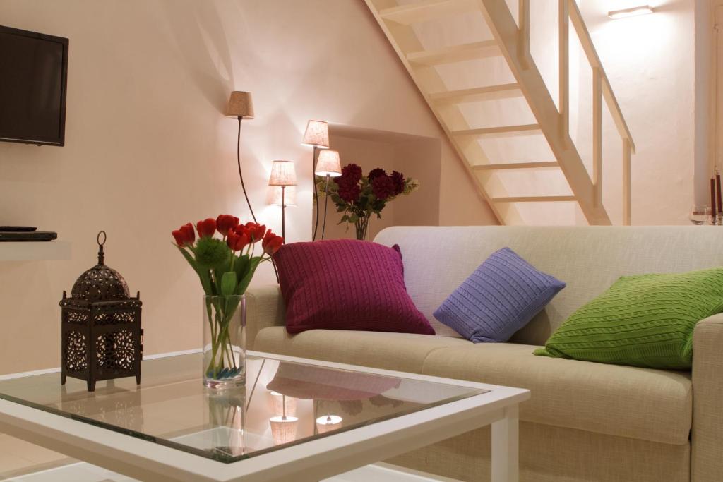 a living room with a couch and a table with flowers at Eden Loft Firenze in Florence