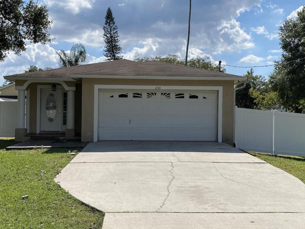 a house with a garage and a driveway at Familiar vacation house come to know Tampa Florida in Tampa