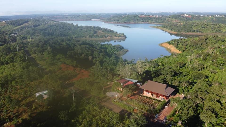 uma vista aérea de uma casa ao lado de um lago em Phuong Nam Gia Trang Farmstay em Gia Nghĩa