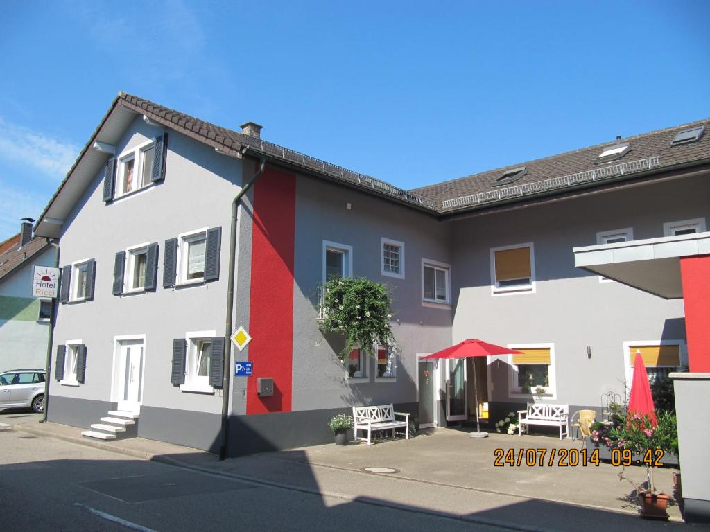 - un bâtiment blanc et rouge avec une table et des chaises dans l'établissement Hotel Ricci, à Rust