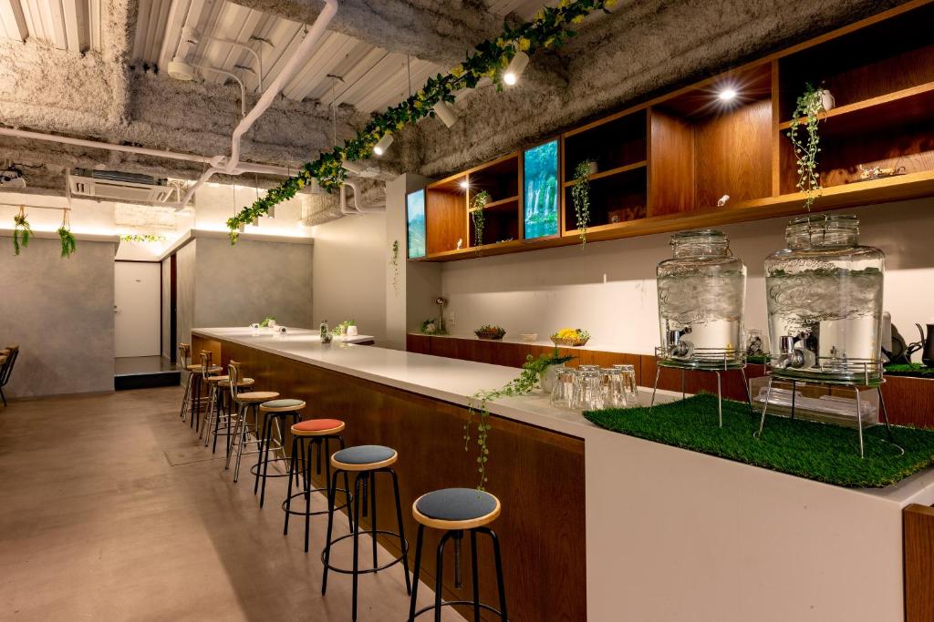 a kitchen with a bar with stools at plat hostel keikyu minowa forest in Tokyo