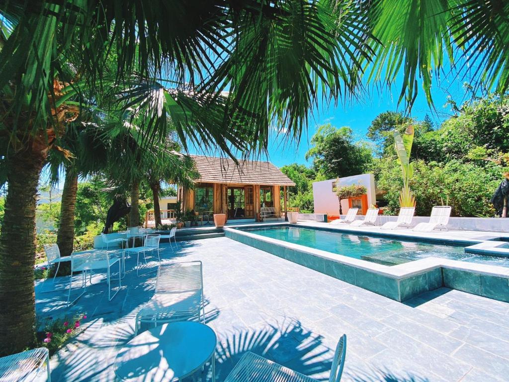 a swimming pool with chairs and a house at ROSE Villas & Resort - Ba Vi in Hanoi