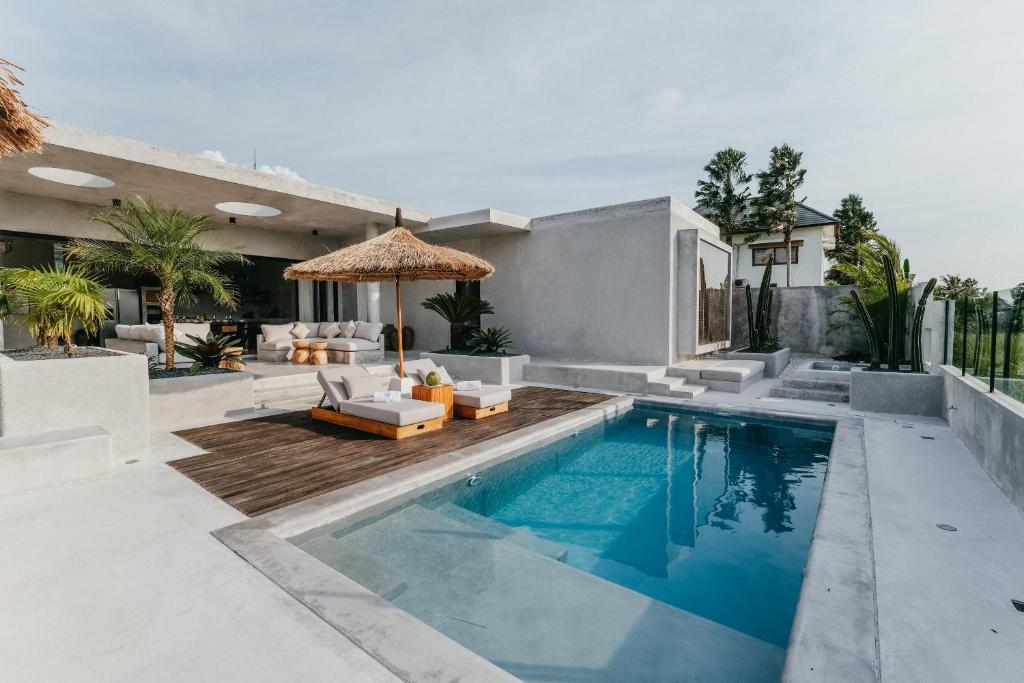 une maison avec une piscine et une terrasse dans l'établissement Concrete Retreat Villa, à Canggu