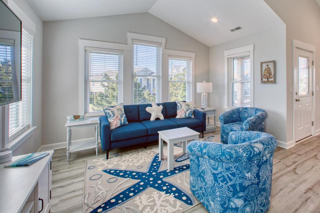 uma sala de estar com um sofá azul e duas cadeiras em Prickly Pear 723 em Avon