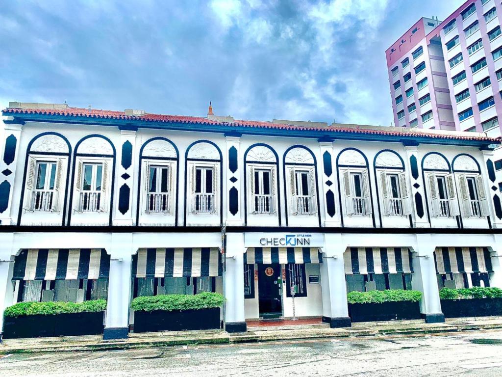 biały budynek z białymi kolumnami i oknami w obiekcie Check-Inn at Little India w Singapurze
