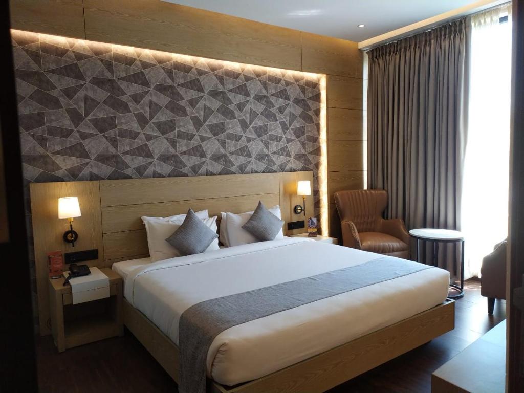 1 dormitorio con 1 cama grande en una habitación de hotel en MothiMahal Residency Thrissur, en Trichūr