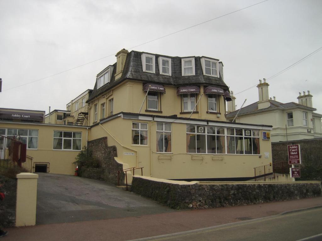 a large yellow building with a black roof at Ashley Court Hotel in Torquay