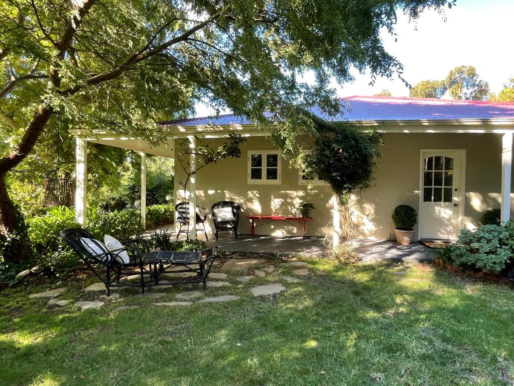 a house with a patio with chairs in the yard at Fleetwood Cottage Bed and Breakfast in Mylor