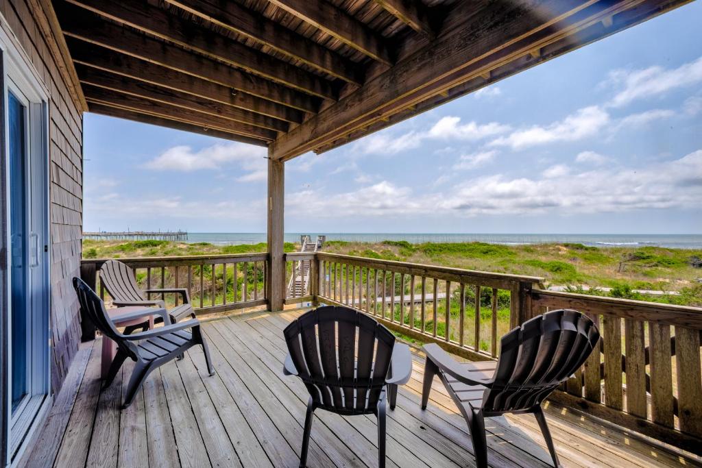 a porch with chairs and a table and a view of the ocean at Sandy's Spot 605 IC in Avon
