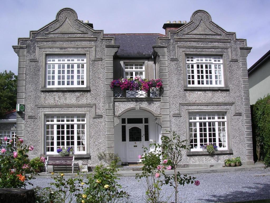una casa de piedra con flores en las ventanas en St Judes B&B en Galway