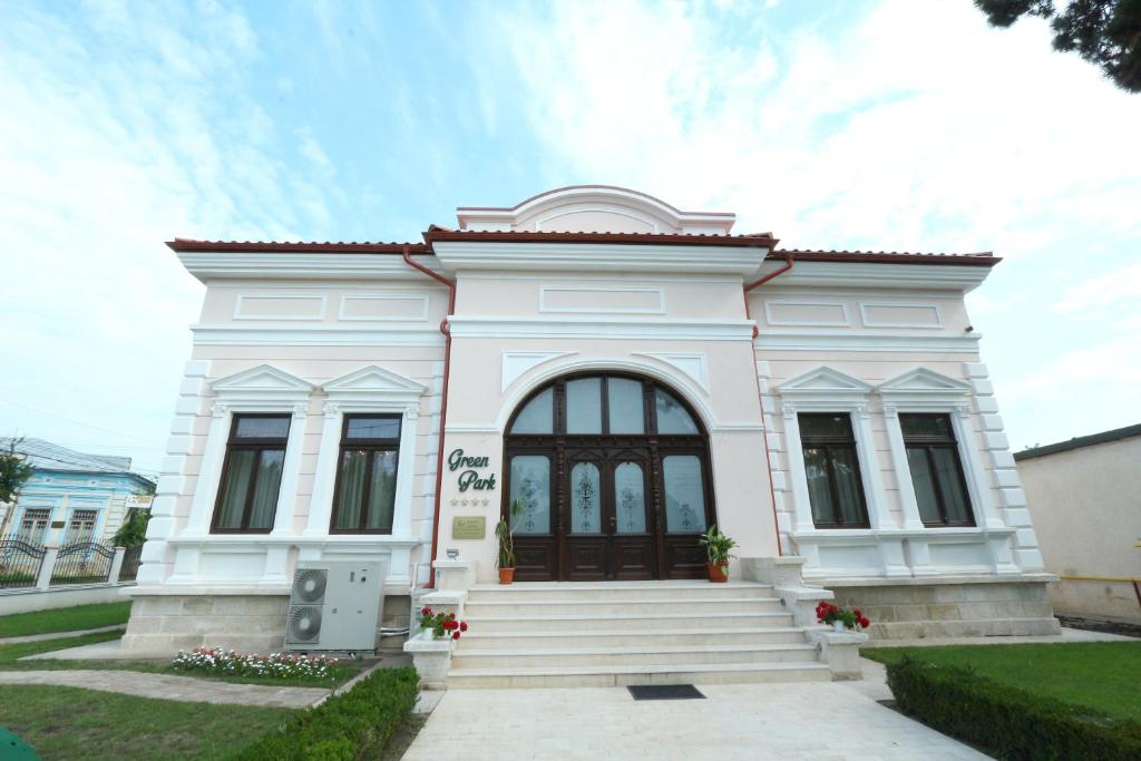 a white building with a black door at Green Park Boutique Hotel in Focşani