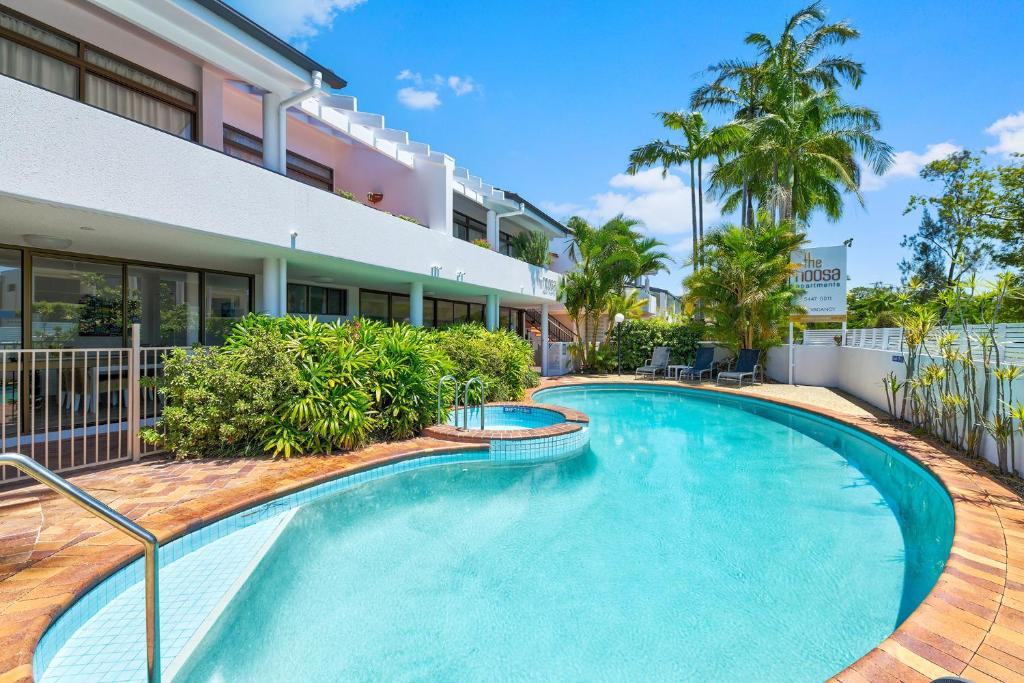 a swimming pool in front of a building at The Noosa Apartments in Noosa Heads