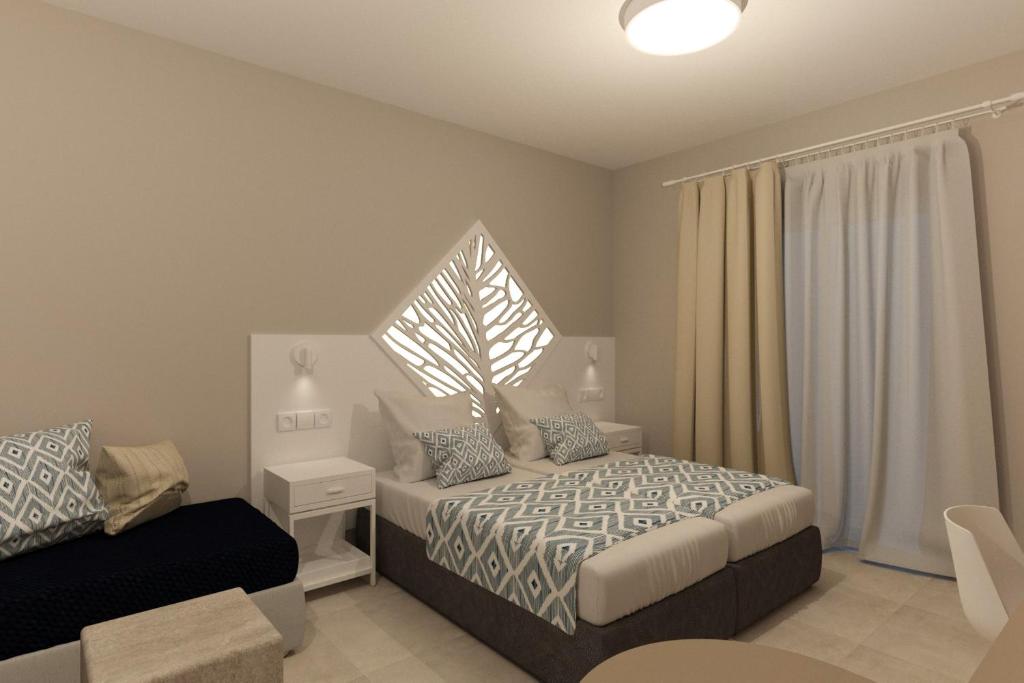 a bedroom with a bed and a chair and a window at Likio Studios in Batsi